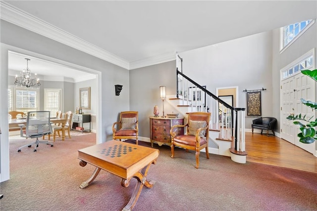 sitting room with crown molding, carpet flooring, and an inviting chandelier