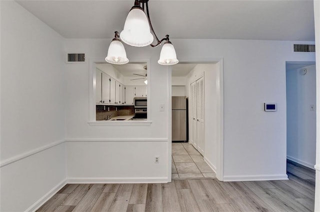 kitchen with white cabinetry, ceiling fan, stainless steel appliances, pendant lighting, and light wood-type flooring