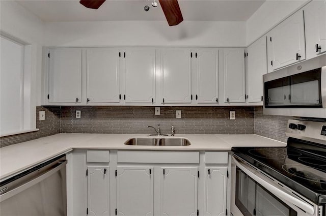 kitchen featuring decorative backsplash, appliances with stainless steel finishes, ceiling fan, sink, and white cabinets