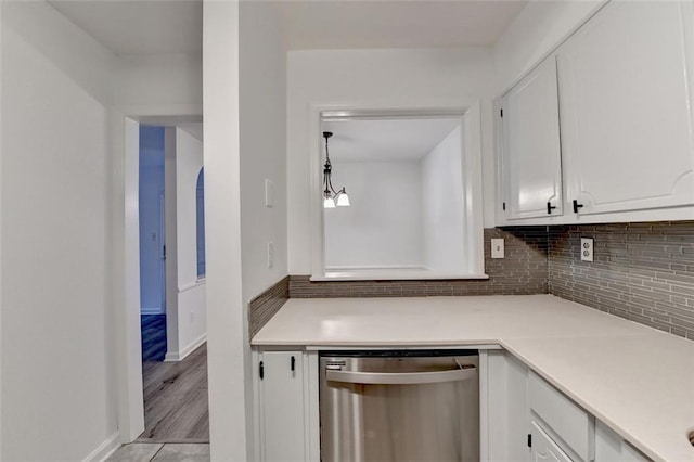kitchen with stainless steel dishwasher, light wood-type flooring, white cabinetry, and tasteful backsplash