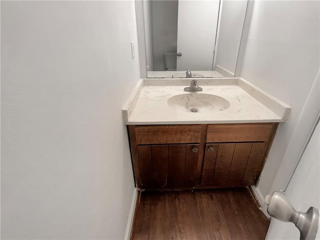 bathroom with hardwood / wood-style floors, vanity, and toilet