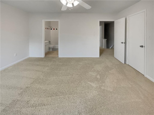 unfurnished bedroom featuring ensuite bath, ceiling fan, and light colored carpet