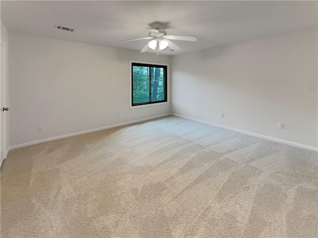 empty room with ceiling fan and light carpet