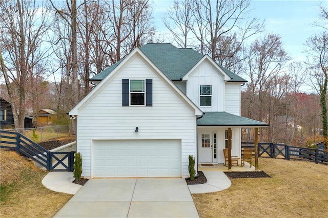 modern inspired farmhouse featuring concrete driveway, fence, a porch, board and batten siding, and a front yard