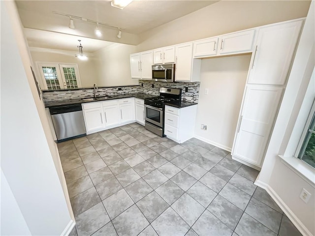 kitchen with sink, rail lighting, appliances with stainless steel finishes, white cabinets, and decorative backsplash