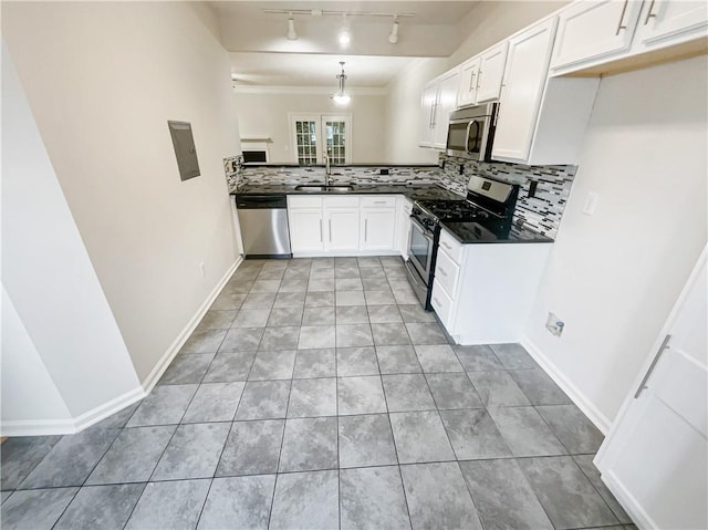 kitchen featuring appliances with stainless steel finishes, decorative light fixtures, sink, white cabinets, and track lighting