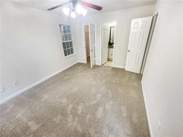 unfurnished bedroom with ensuite bathroom, light colored carpet, and ceiling fan