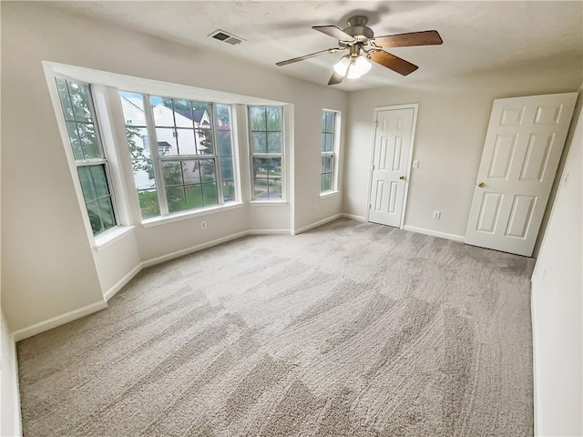 carpeted empty room featuring ceiling fan