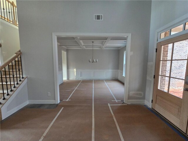 interior space with beamed ceiling, coffered ceiling, and an inviting chandelier