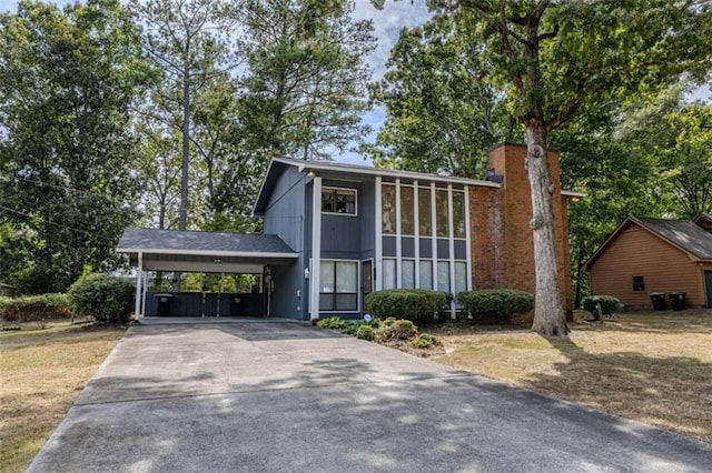 view of front of home featuring a sunroom and a carport