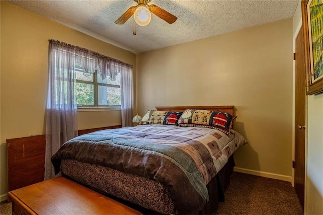 bedroom featuring a textured ceiling, dark colored carpet, and ceiling fan