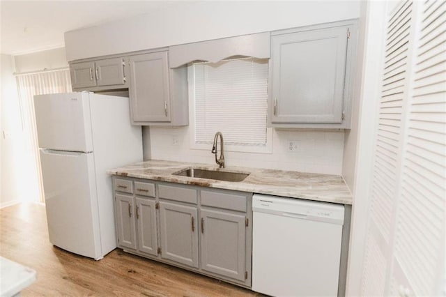 kitchen with white appliances, sink, decorative backsplash, gray cabinets, and light hardwood / wood-style floors