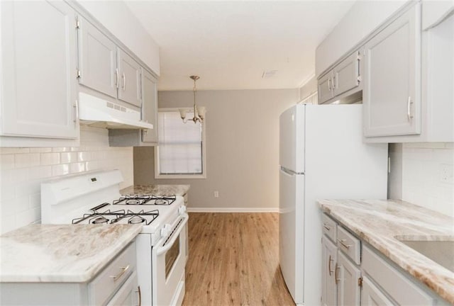 kitchen with decorative backsplash, light hardwood / wood-style flooring, hanging light fixtures, and white appliances