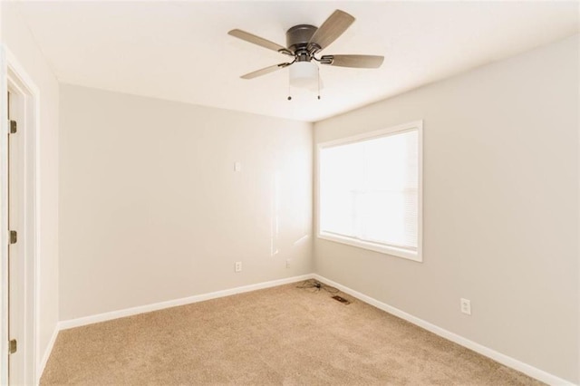 carpeted spare room with ceiling fan