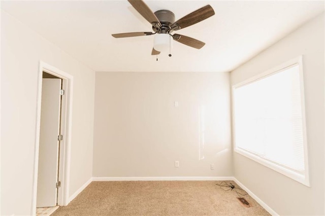 carpeted spare room with plenty of natural light and ceiling fan