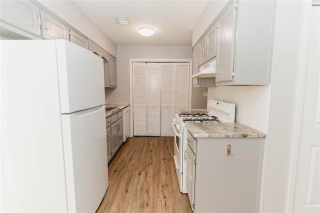 kitchen with white cabinetry, extractor fan, white appliances, decorative backsplash, and light wood-type flooring