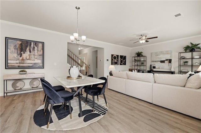 dining space with ceiling fan with notable chandelier, crown molding, and light hardwood / wood-style flooring