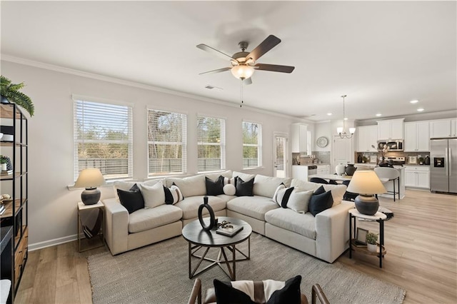 living room featuring crown molding, ceiling fan with notable chandelier, and light hardwood / wood-style flooring