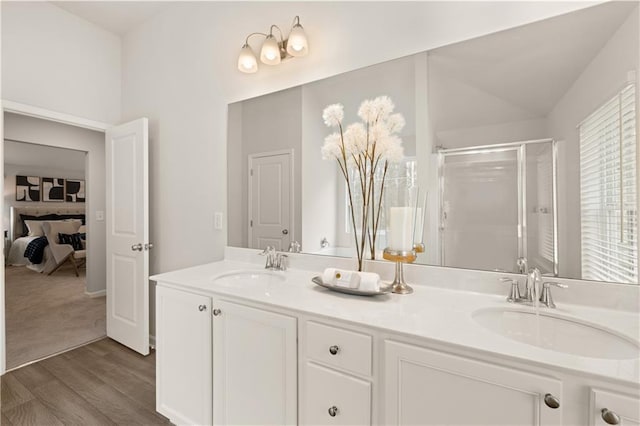 bathroom featuring a shower with shower door, vanity, lofted ceiling, and hardwood / wood-style flooring