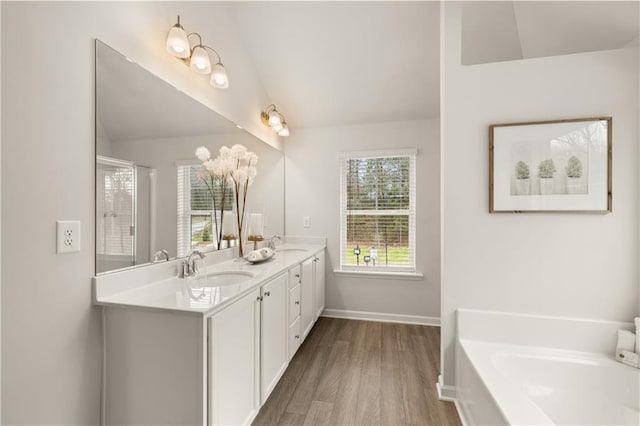 bathroom with vaulted ceiling, separate shower and tub, hardwood / wood-style floors, and vanity