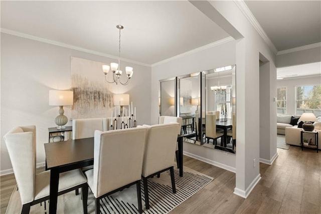 dining space featuring crown molding, an inviting chandelier, and hardwood / wood-style flooring