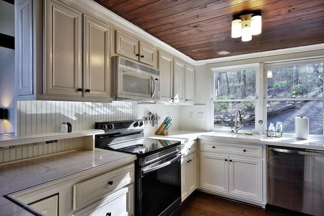 kitchen featuring wood ceiling, white cabinets, tile counters, and appliances with stainless steel finishes