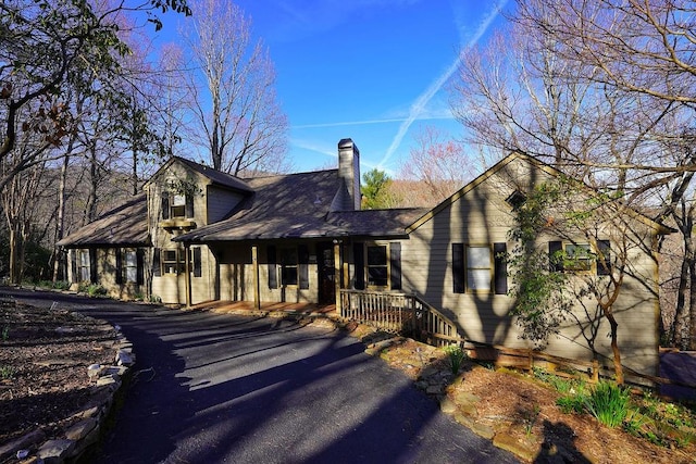 view of front facade with a chimney and a porch
