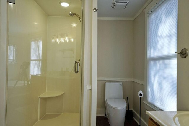 bathroom with a stall shower, crown molding, toilet, vanity, and visible vents