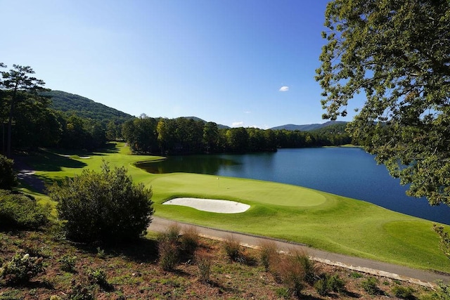 view of property's community with golf course view and a water view