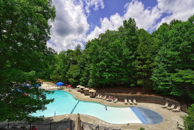pool with fence and a patio