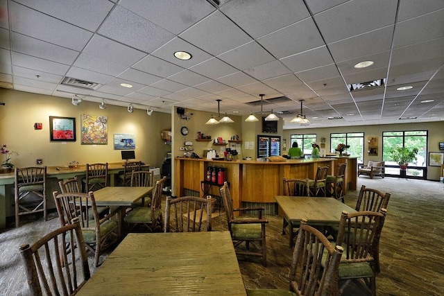 dining space featuring visible vents, rail lighting, and a drop ceiling
