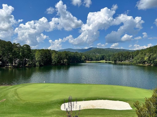 surrounding community featuring view of golf course, a water view, and a view of trees