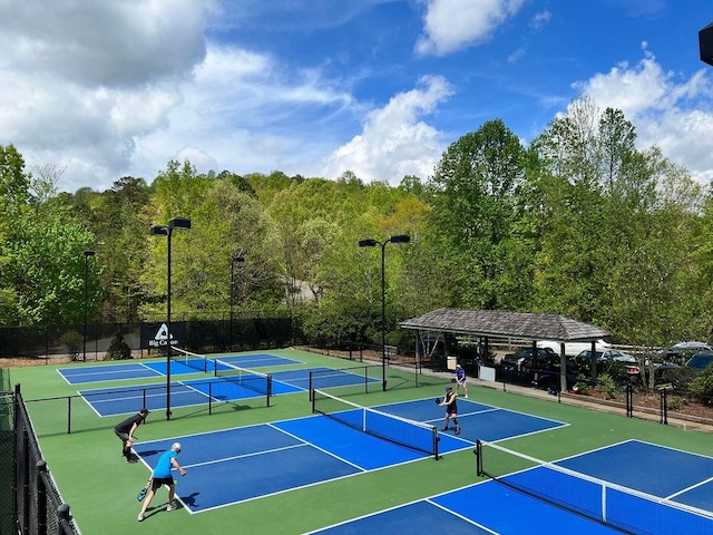 view of tennis court featuring fence and community basketball court