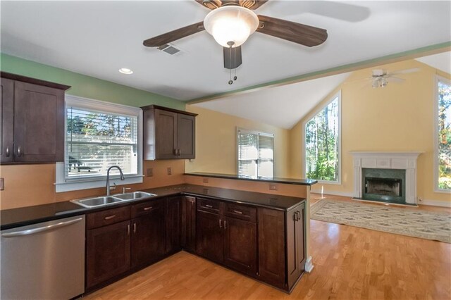 kitchen with sink, light wood-type flooring, stainless steel dishwasher, and kitchen peninsula