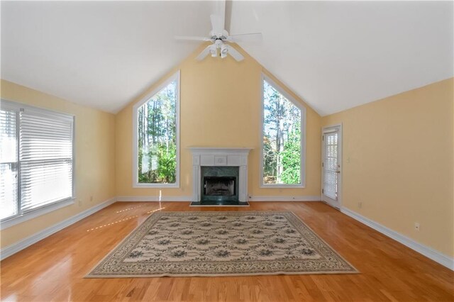 living room with lofted ceiling, a fireplace, ceiling fan, and a healthy amount of sunlight