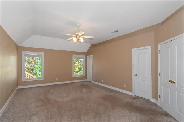 spare room featuring lofted ceiling, ceiling fan, and carpet