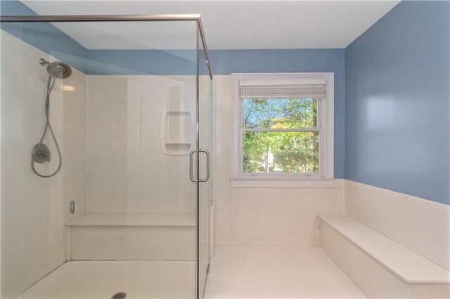 bathroom featuring a shower with door