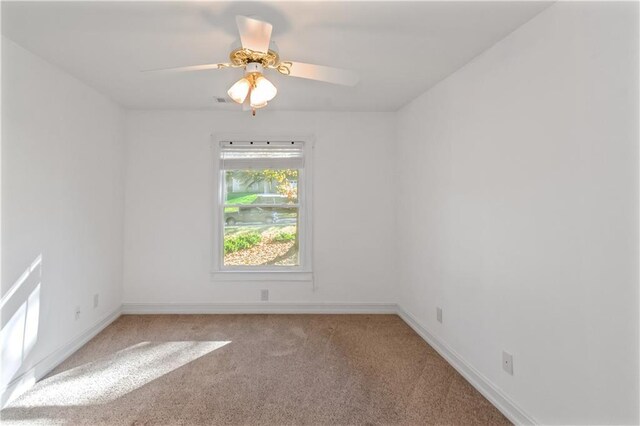 spare room with ceiling fan and light colored carpet