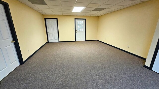 spare room with a paneled ceiling and carpet