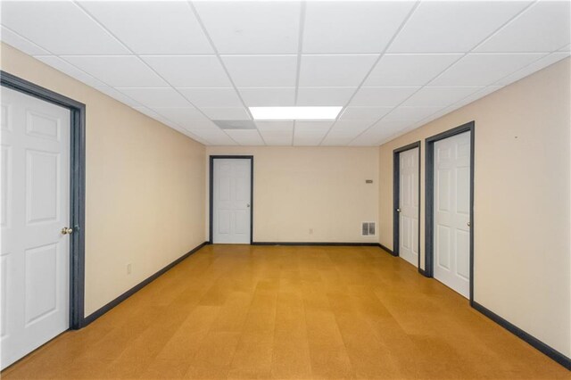 unfurnished room with a paneled ceiling and carpet flooring