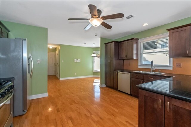 kitchen with appliances with stainless steel finishes, ceiling fan, pendant lighting, sink, and dark brown cabinets