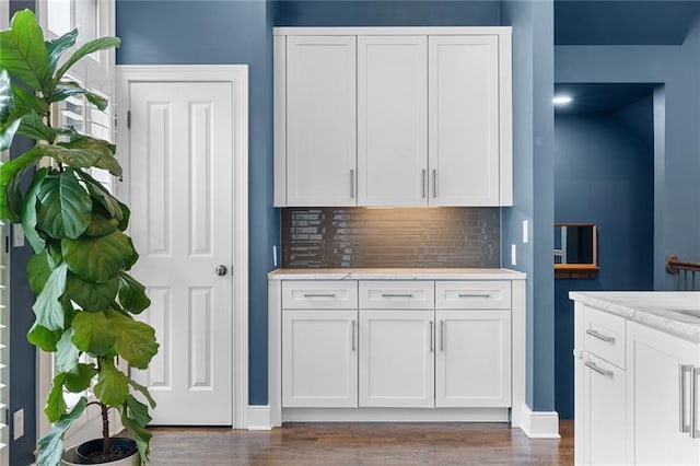 kitchen featuring white cabinetry, dark hardwood / wood-style flooring, light stone counters, and tasteful backsplash