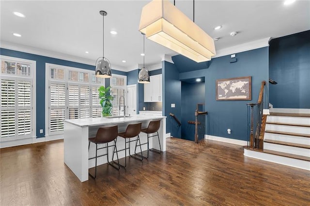 kitchen featuring white cabinetry, sink, decorative light fixtures, and a center island