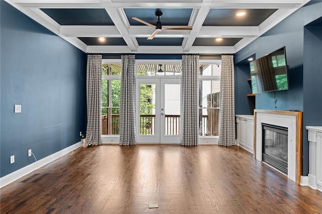 unfurnished living room featuring beamed ceiling, plenty of natural light, coffered ceiling, and french doors