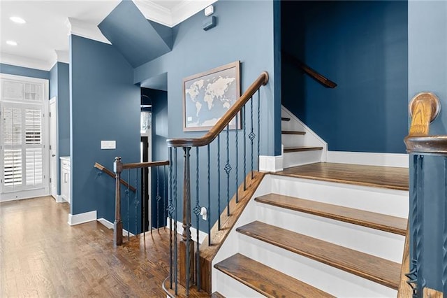 stairs featuring crown molding and wood-type flooring