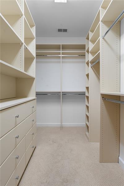 walk in closet featuring light carpet