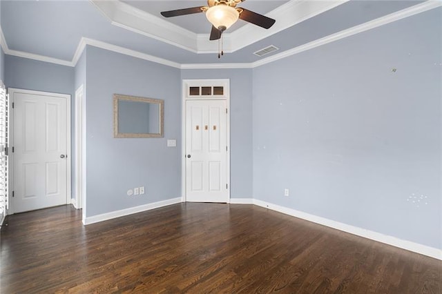 unfurnished room with ornamental molding, dark wood-type flooring, ceiling fan, and a tray ceiling