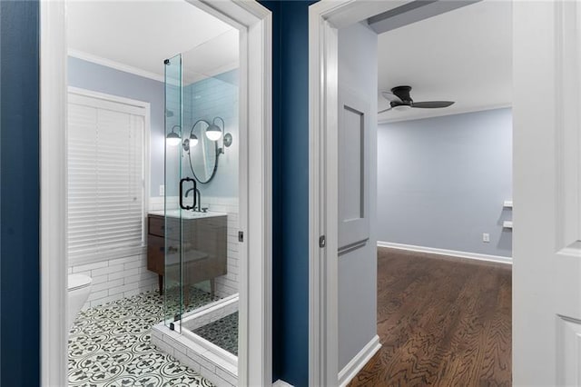 bathroom featuring ceiling fan, hardwood / wood-style floors, an enclosed shower, ornamental molding, and toilet