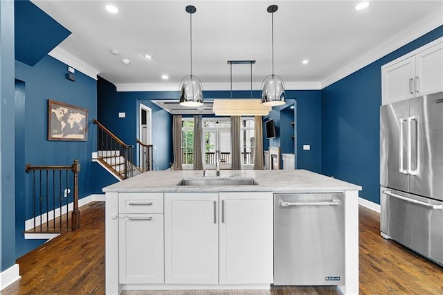 kitchen featuring pendant lighting, appliances with stainless steel finishes, a kitchen island with sink, and white cabinets