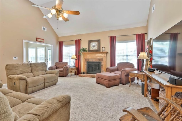 carpeted living room featuring a fireplace, plenty of natural light, high vaulted ceiling, and ceiling fan